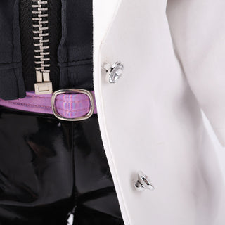 Detail shot of Naya doll's removable white jacket and black pants outfit, showing material texture and functional zipper.