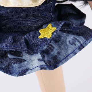 Detailed view of the tiered denim skirt on Wanru doll showing stitching and layers