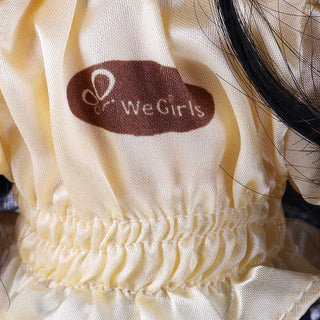 Close-up of WeGirls logo embroidery on Wanru doll's yellow tee