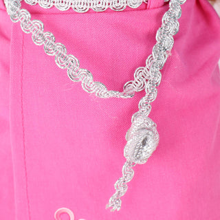 Detailed close-up of the pink pleated skirt showing precise folds and fabric texture